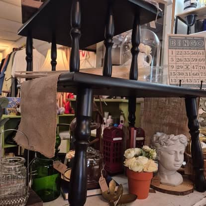 A black table with a vase on top of it.